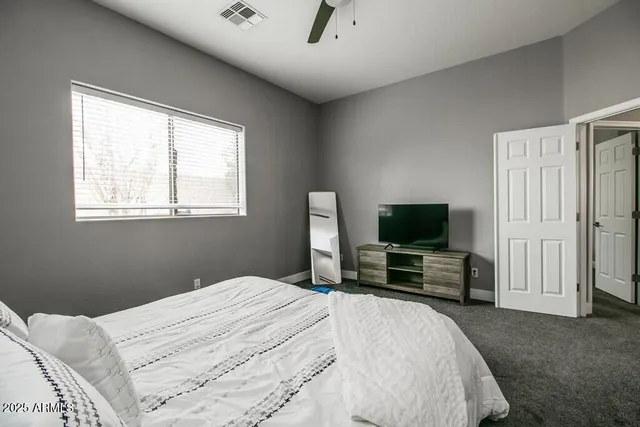 a bedroom with a bed and a flat screen tv