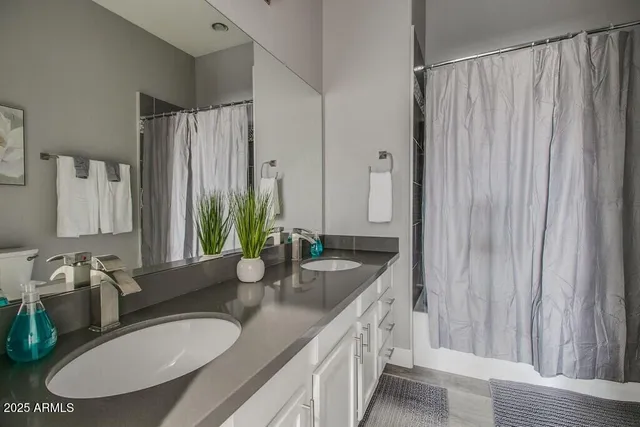 a bathroom with a double vanity sink and a mirror