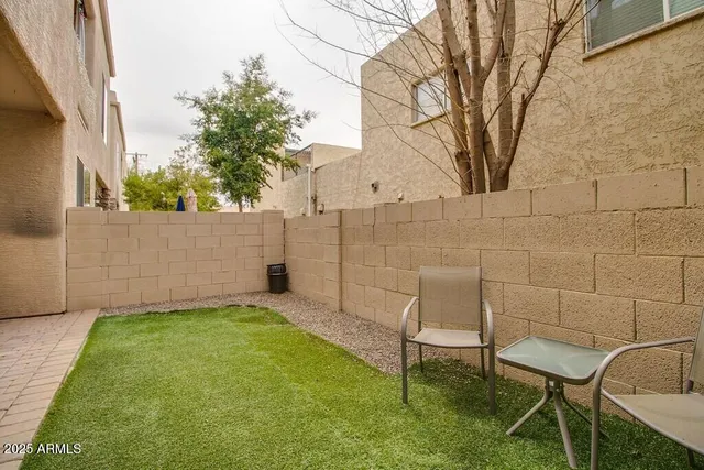 a backyard of a house with table and chairs
