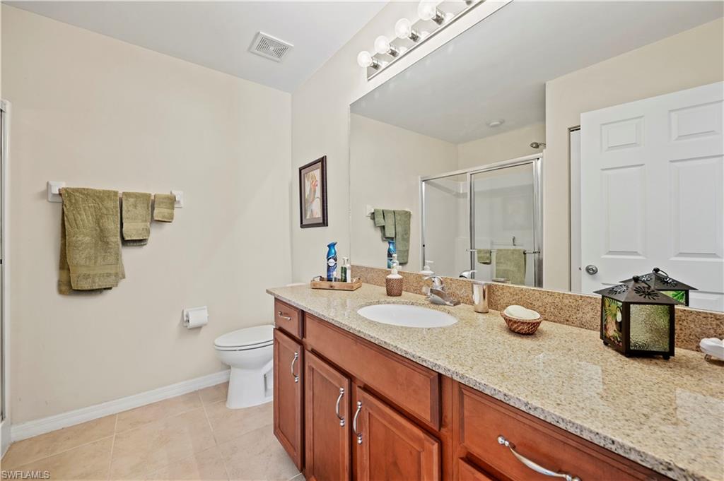 3922 Cherrybrook Loop Fort Myers, FL 33966 - Photo 12 of 38 a bathroom with a granite countertop sink a toilet and a mirror