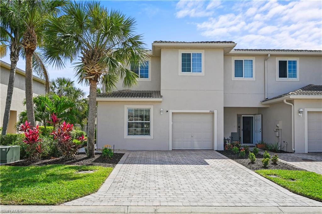3922 Cherrybrook Loop Fort Myers, FL 33966 - Photo 2 of 38 a front view of house and yard with beautiful flowers and green space
