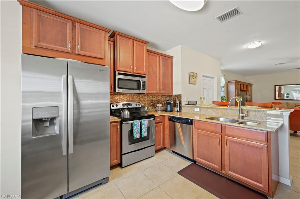 3922 Cherrybrook Loop Fort Myers, FL 33966 - Photo 6 of 38 a kitchen with stainless steel appliances granite countertop a refrigerator and a stove top oven