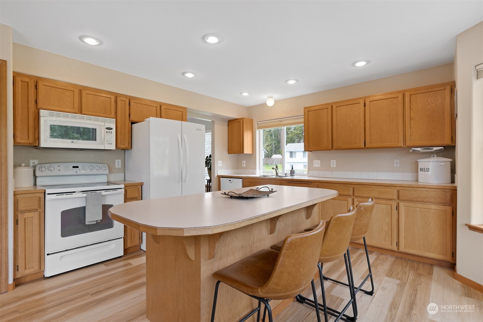 1308 Roma Road Bellingham, WA 98226 - Photo 8 of 39 a kitchen with stainless steel appliances granite countertop a table chairs sink refrigerator and cabinets