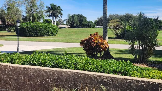 a view of a garden with a bench in front of main door
