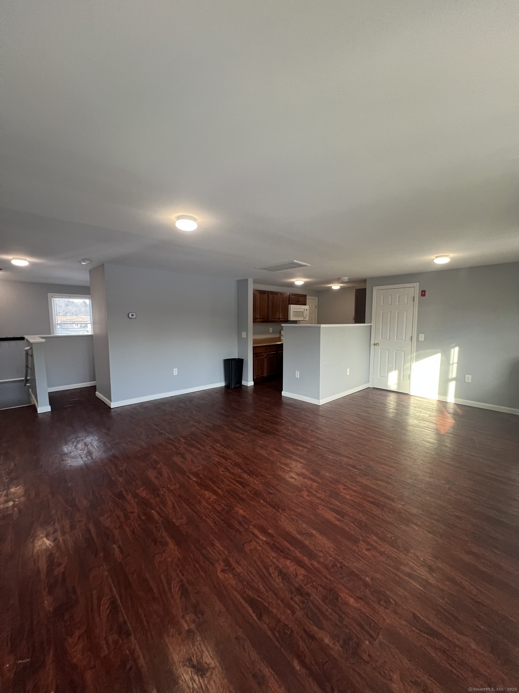 a view of empty room with wooden floor