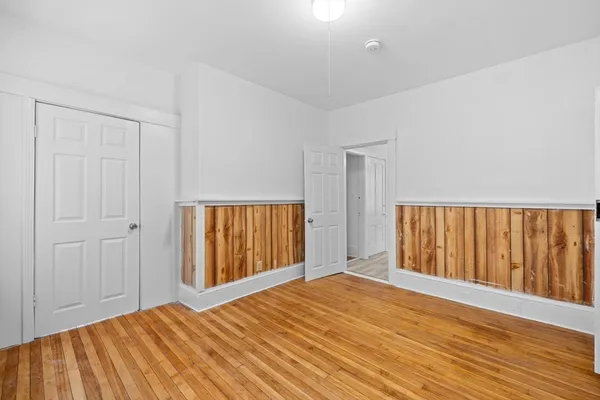 a view of a room with wooden floor and a window