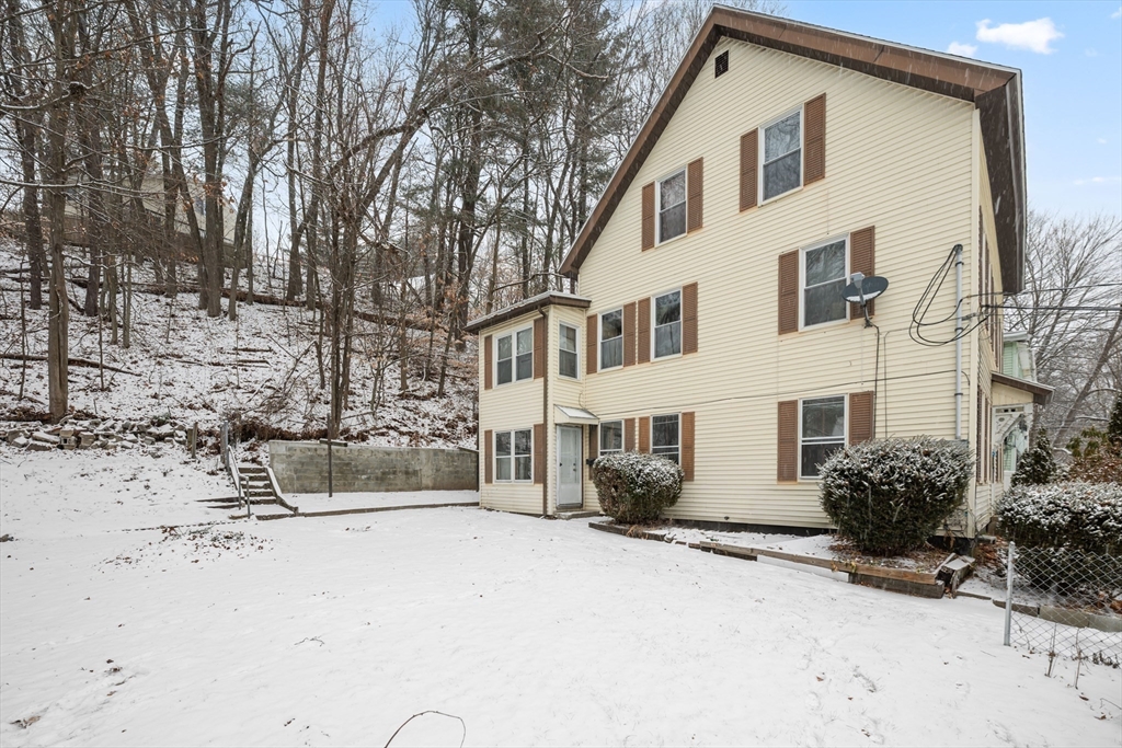 20 Temple Street, Unit 1 Fitchburg, MA 01420 - Photo 19 of 25 a view of a white house with a yard covered in snow