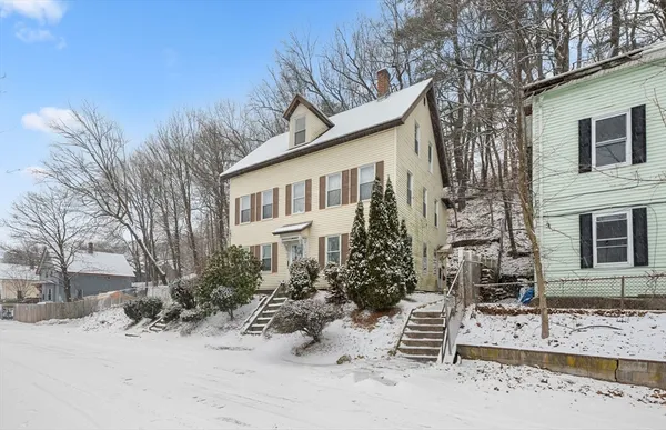 a view of a house with a yard covered in snow