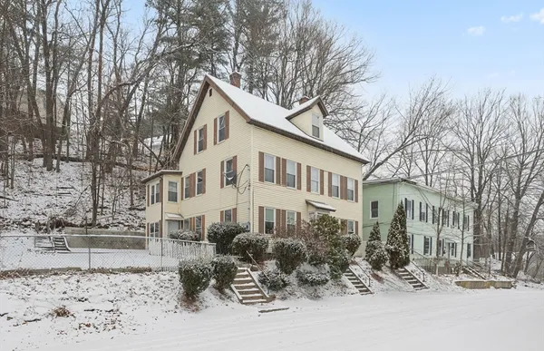 a view of a house with a yard covered in snow
