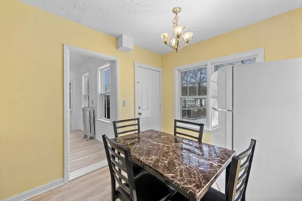 a view of a dining room with furniture and chandelier