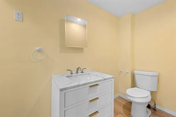a bathroom with a granite countertop toilet sink and mirror