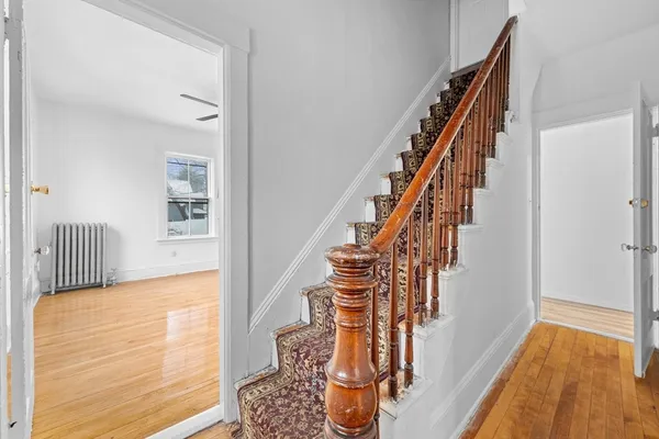 a view of staircase with wooden floor and a rug