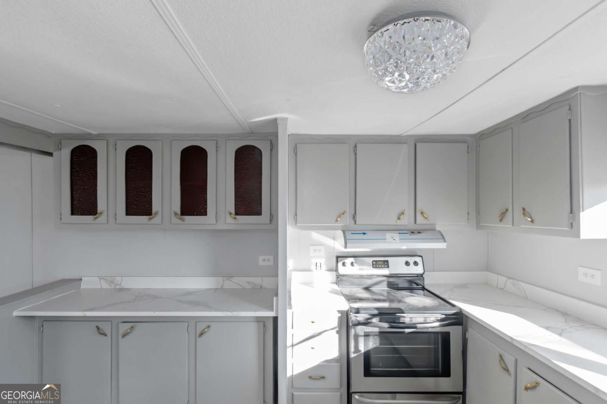 24 David Drive Hampton, GA 30228 - Photo 11 of 21 a kitchen with stainless steel appliances a stove a sink and cabinets