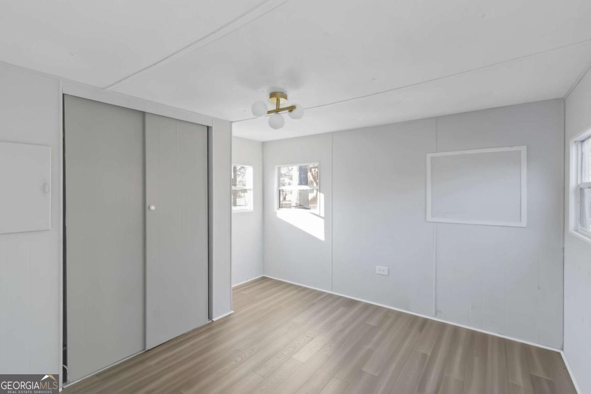 24 David Drive Hampton, GA 30228 - Photo 16 of 21 a view of an empty room with wooden floor and a window