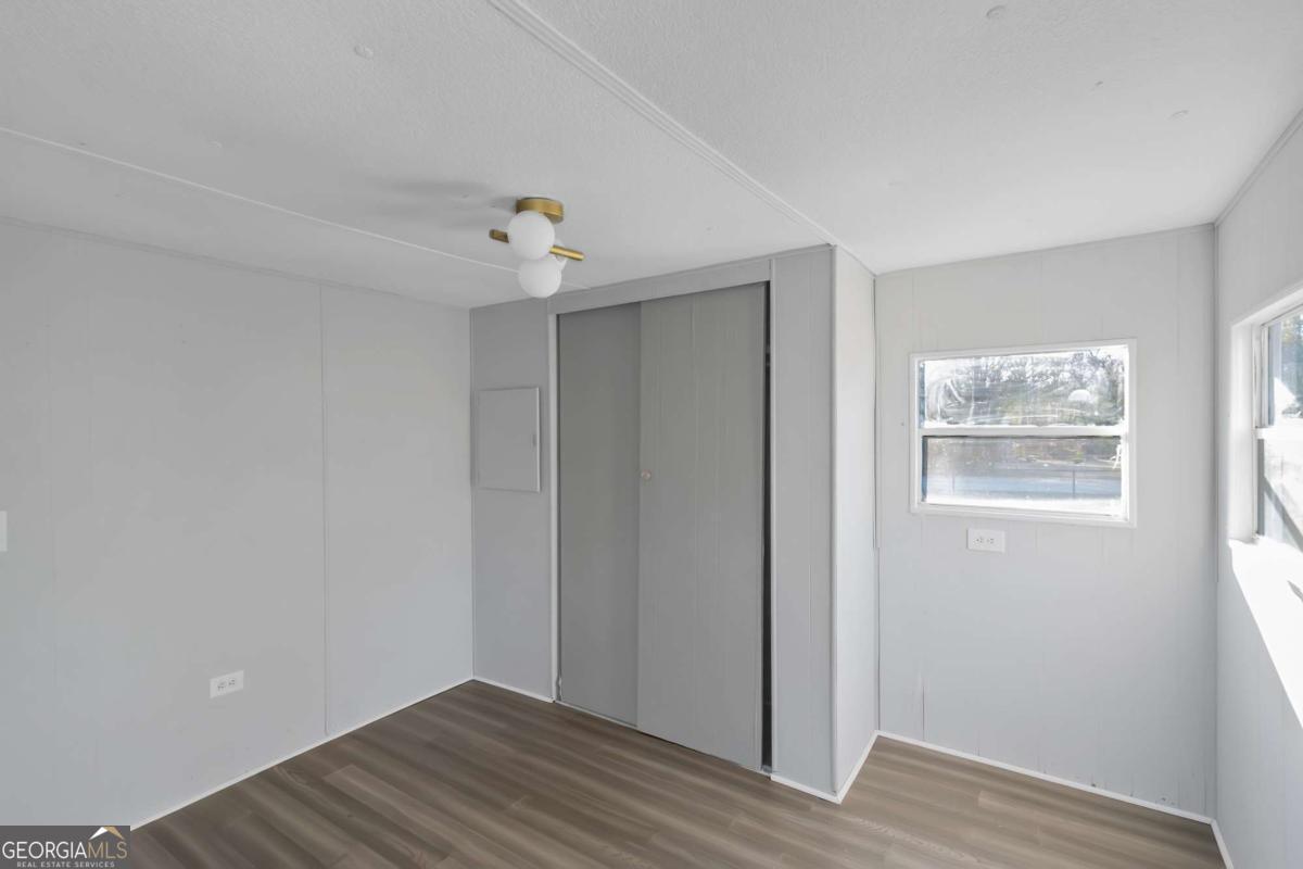 24 David Drive Hampton, GA 30228 - Photo 17 of 21 a view of an empty room with wooden floor and a window