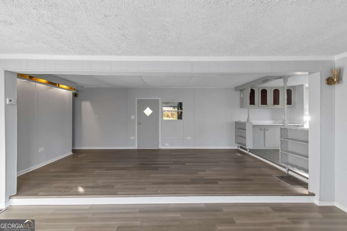 24 David Drive Hampton, GA 30228 - Photo 6 of 21 a view of a hallway with wooden floor and a living room