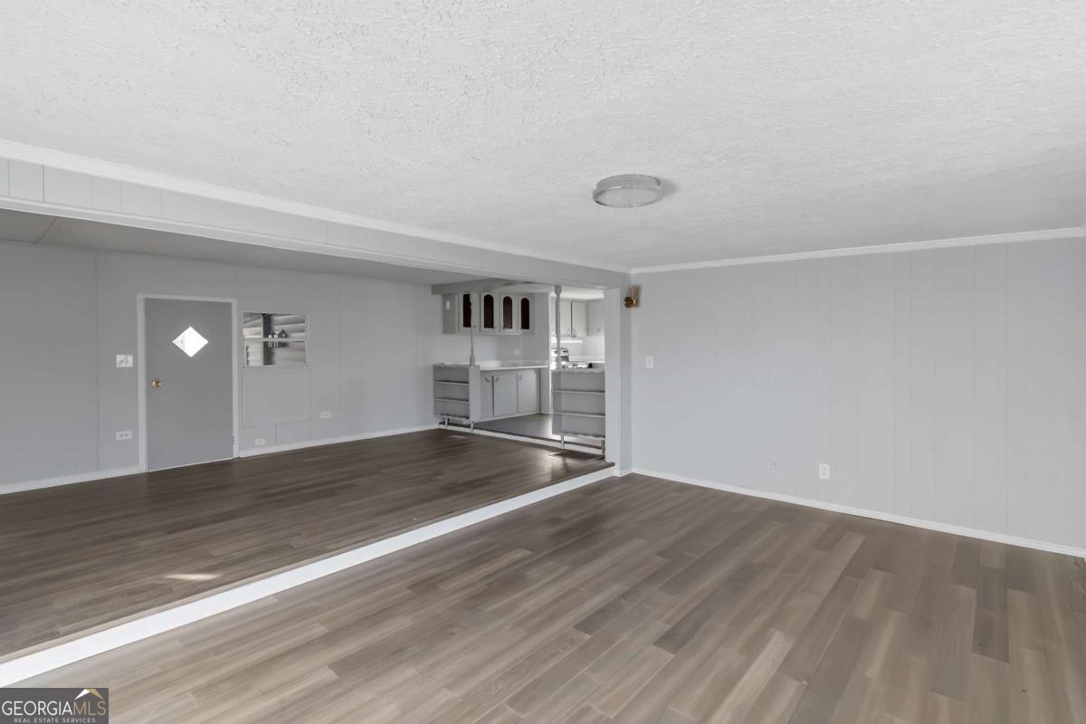 24 David Drive Hampton, GA 30228 - Photo 8 of 21 an empty room with wooden floor and windows