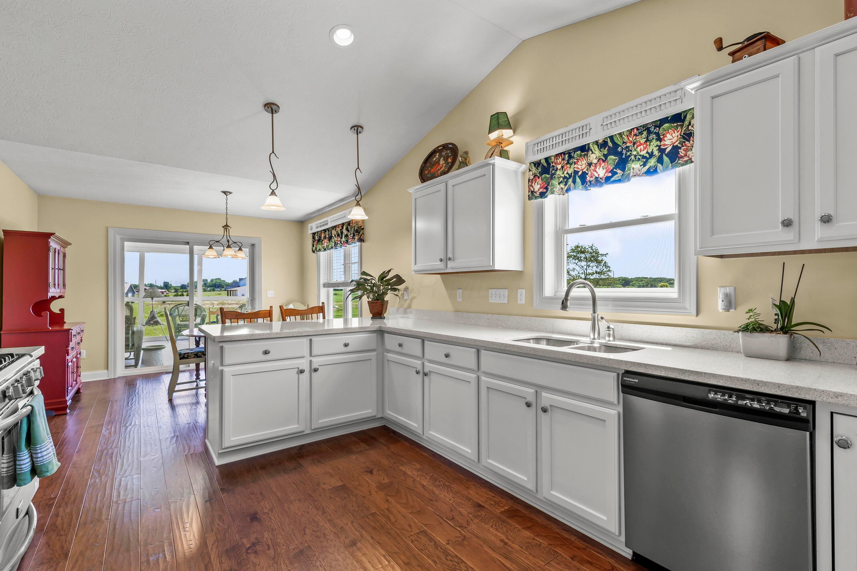 3582 Panhandle Road Delaware, OH 43015 - Photo 27 of 65 • New englewood flooring ~ 2015 • Ivory painted walls • Cathedral ceiling • New quartz countertops ~ 2015 • Can lighting • White cabinets • Double bowl, stainless steel sink with sprayer • Frigidaire® dishwasher • New Frigidaire® refrigerator ~ 2024 • Frigidaire® microwave • Frigidaire® gas range • Breakfast bar ledge • Disposal • Pendant lights over Dinette • Electric outlet above cabinets
