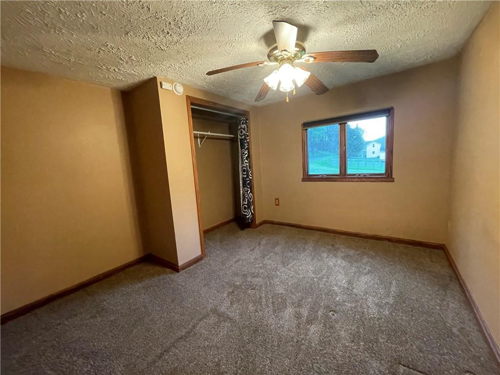 474 Iron Rock Road Waynesburg, PA 15370 - Photo 8 of 15 an empty room with a chandelier fan and windows
