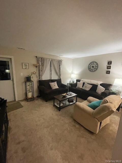 81 Rocky Point Yaphank Road, Unit 145 Rocky Point, NY 11778 - Photo 3 of 11 Living area with light colored carpet