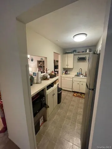 a kitchen with a sink a refrigerator and cabinets