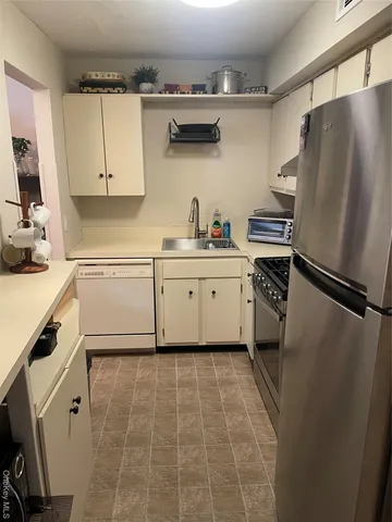a kitchen with stainless steel appliances a refrigerator sink and cabinets
