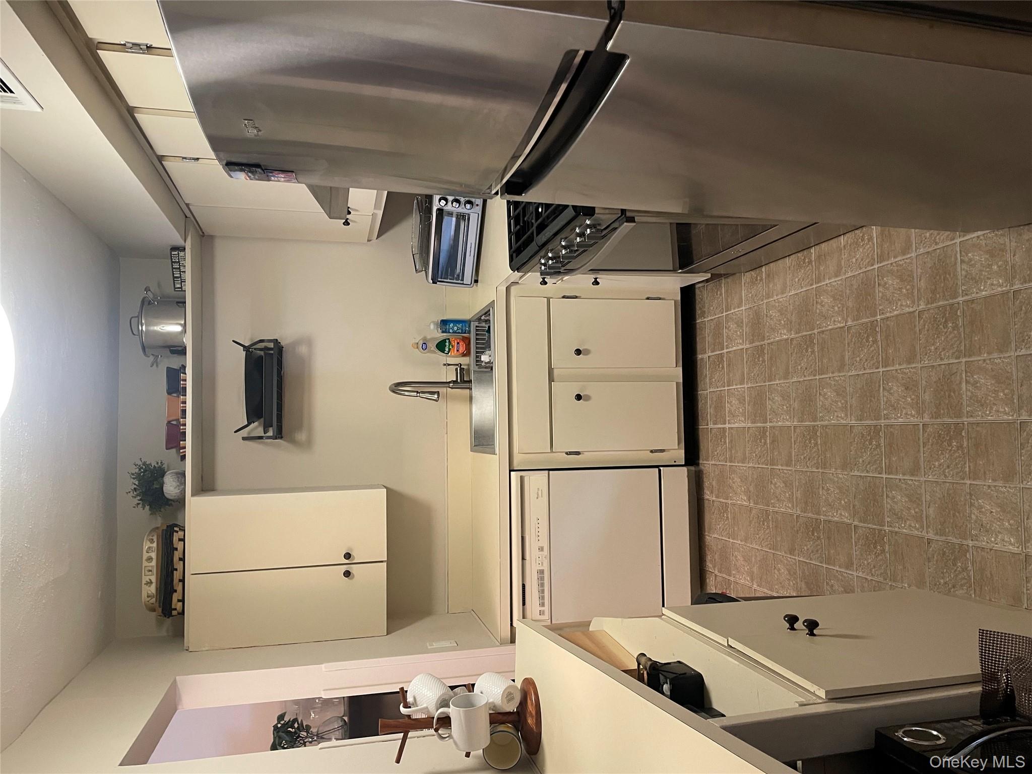 81 Rocky Point Yaphank Road, Unit 145 Rocky Point, NY 11778 - Photo 8 of 11 a kitchen with stainless steel appliances a refrigerator sink and cabinets