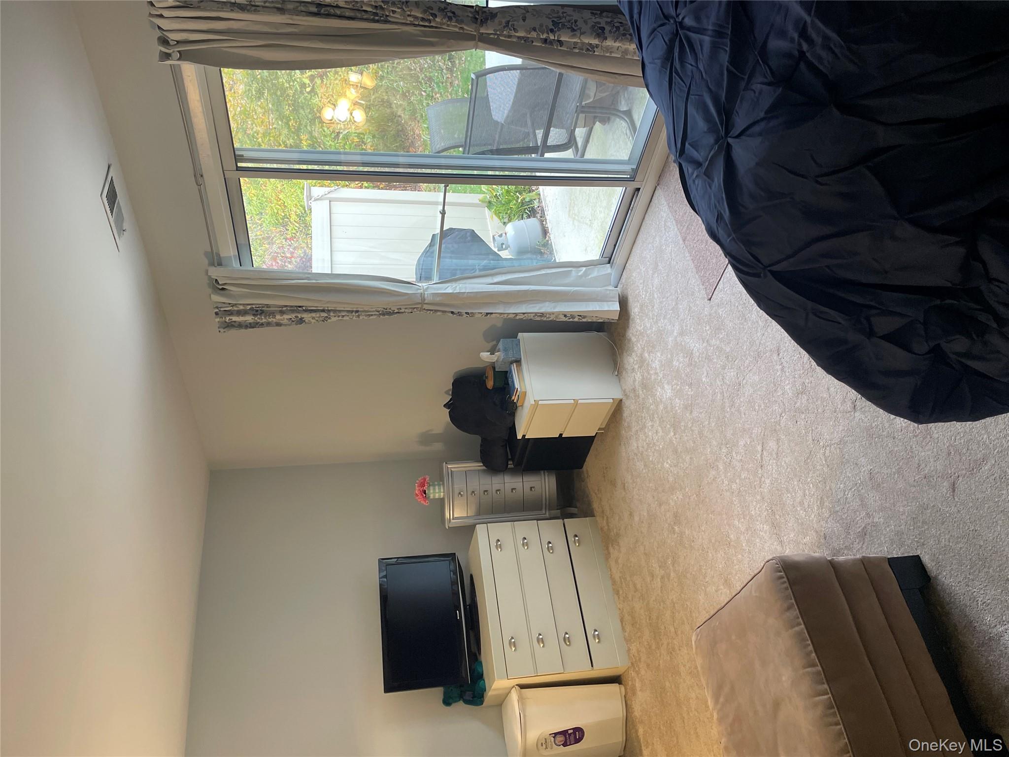 81 Rocky Point Yaphank Road, Unit 145 Rocky Point, NY 11778 - Photo 10 of 11 a bedroom with a bed and large window