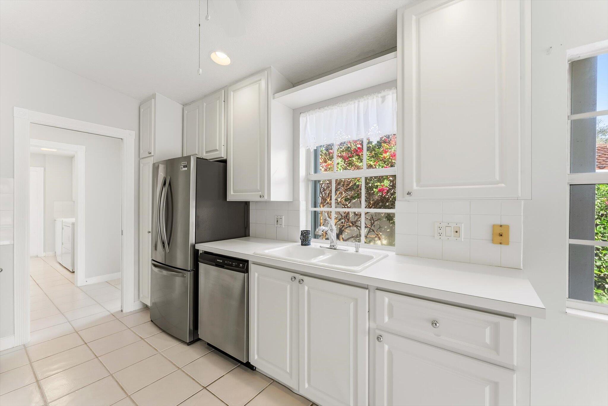 2162 Blue Springs Road West Palm Beach, FL 33411 - Photo 11 of 42 a kitchen with stainless steel appliances a refrigerator sink and cabinets