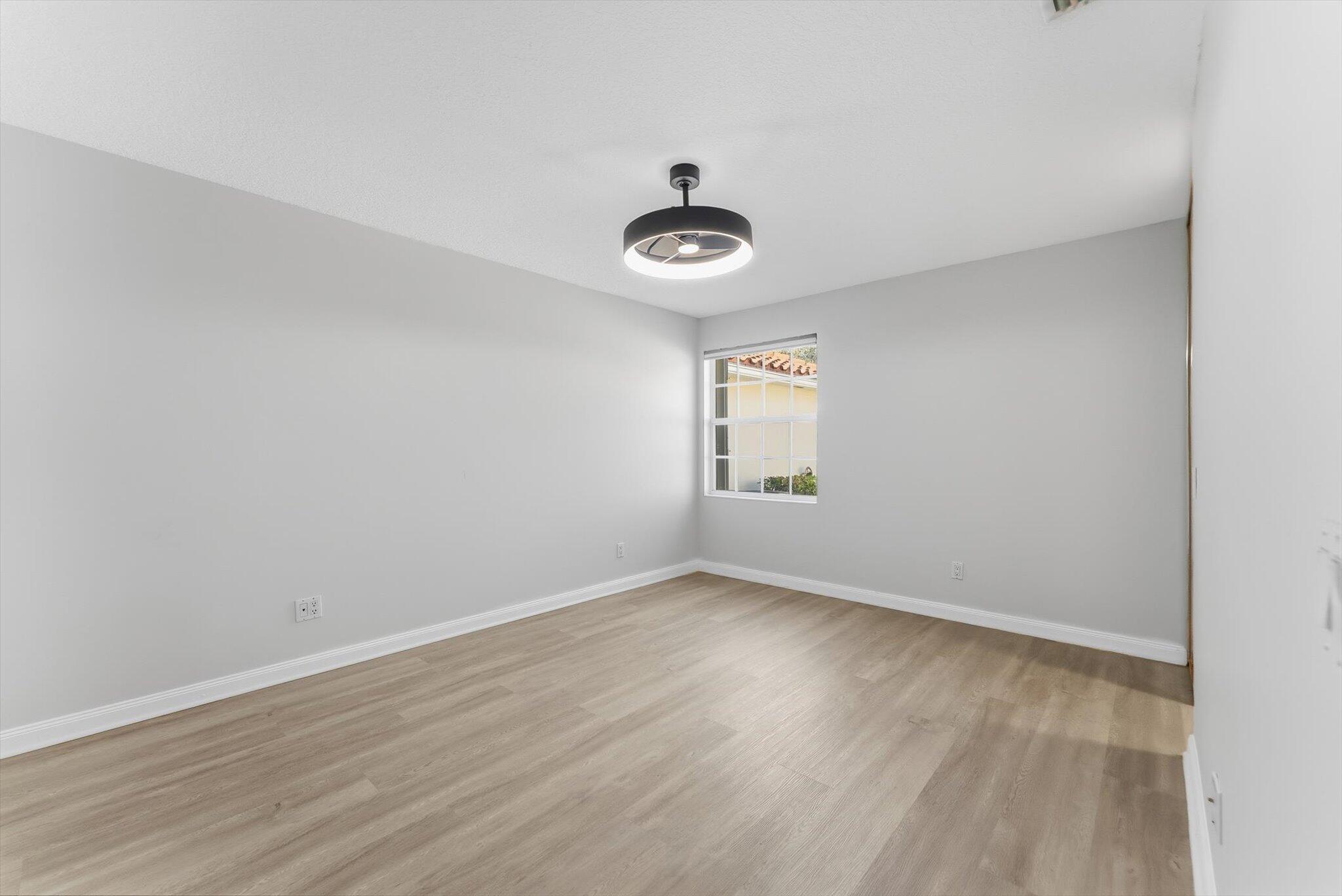 2162 Blue Springs Road West Palm Beach, FL 33411 - Photo 18 of 42 an empty room with wooden floor and windows