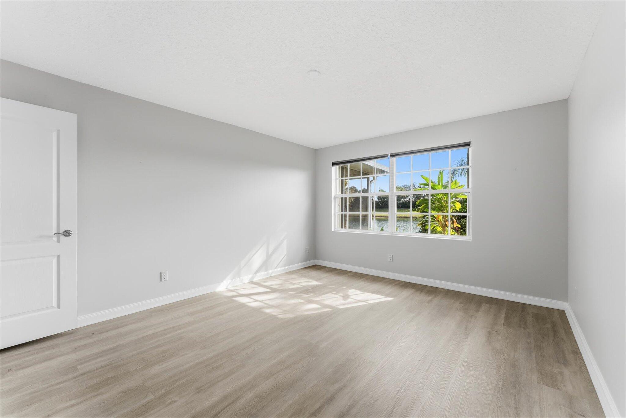 2162 Blue Springs Road West Palm Beach, FL 33411 - Photo 23 of 42 an empty room with wooden floor and windows