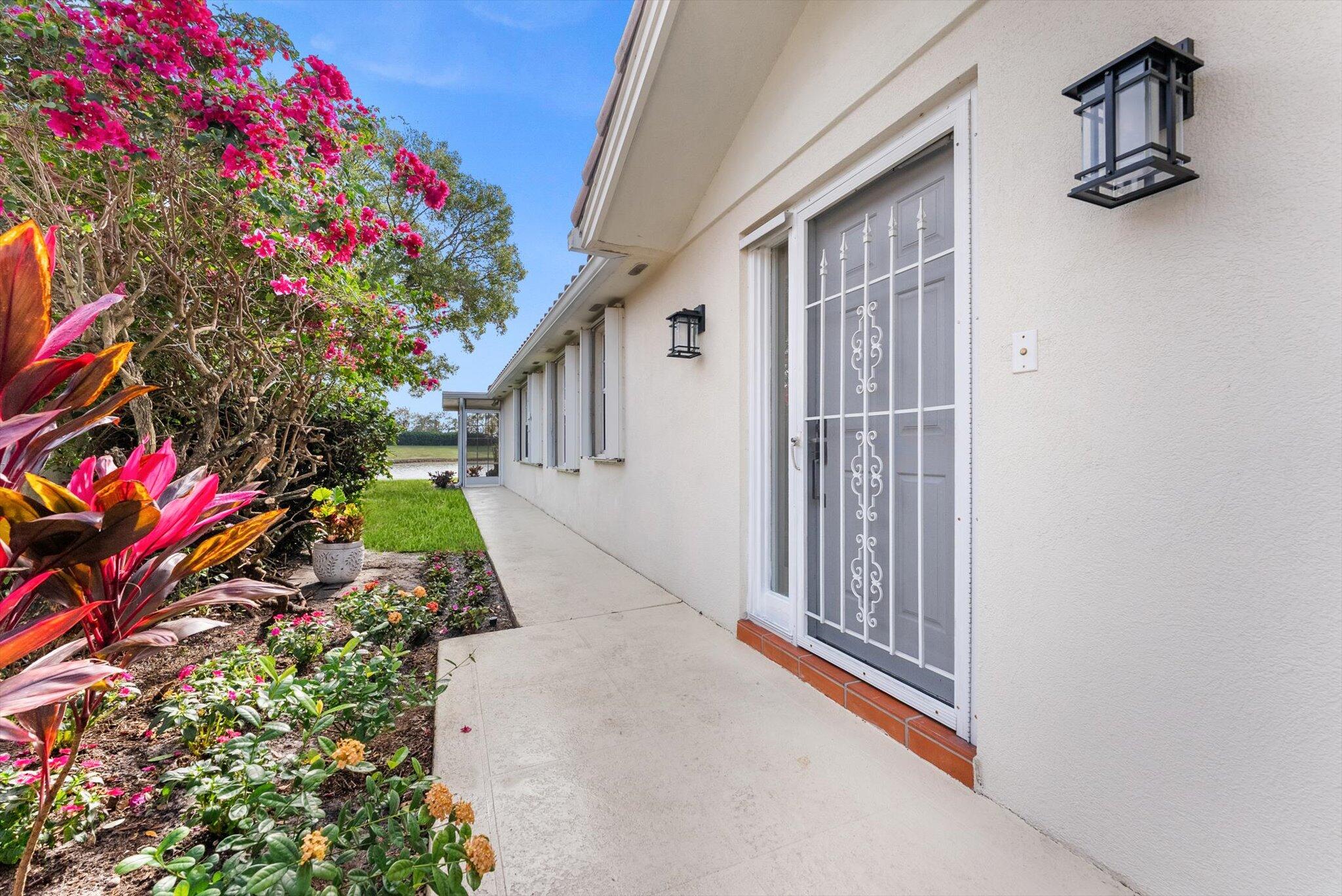 2162 Blue Springs Road West Palm Beach, FL 33411 - Photo 3 of 42 a view of a house with a flower garden
