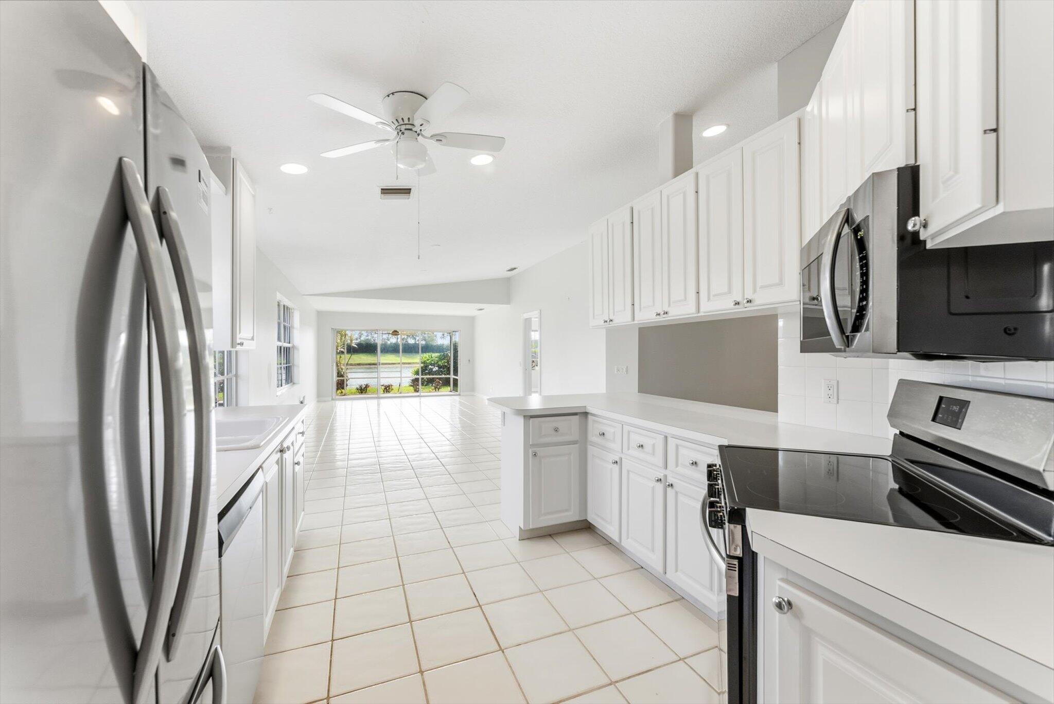 2162 Blue Springs Road West Palm Beach, FL 33411 - Photo 10 of 42 a kitchen with stainless steel appliances a refrigerator sink and stove