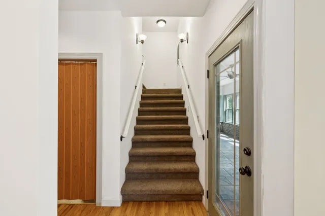 a kitchen with granite countertop a stove chairs and wooden floor