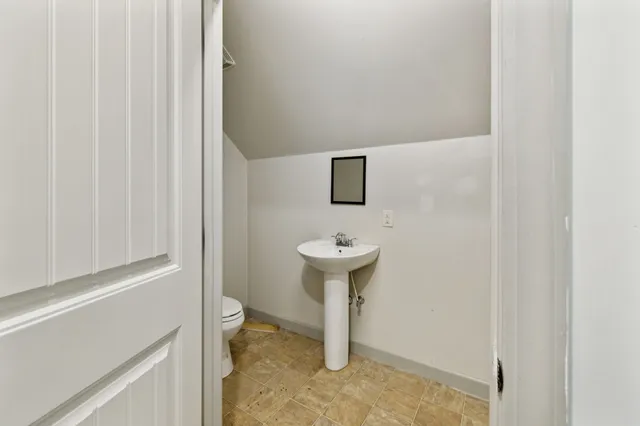 a backyard of a house with table and chairs under an umbrella
