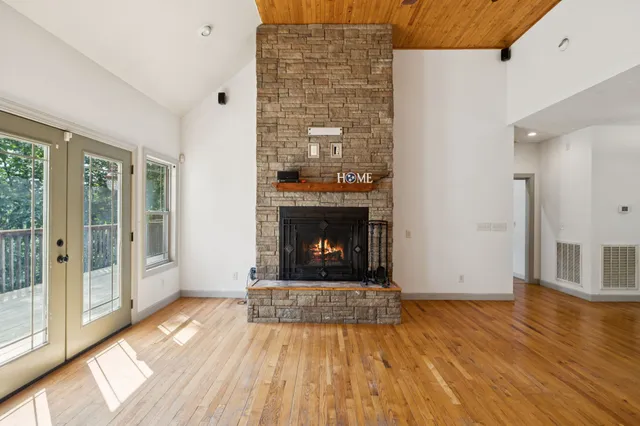 a large kitchen with stainless steel appliances granite countertop a stove and a view of living room