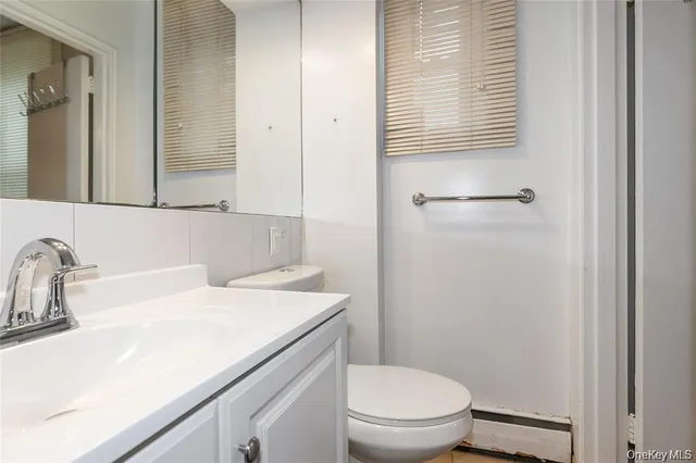 a bathroom with a sink toilet vanity and mirror