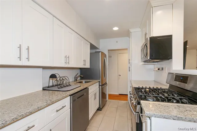 a kitchen with stainless steel appliances granite countertop a sink stove top oven and cabinets