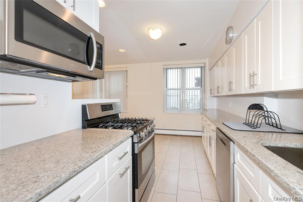 25 Canterbury Road, Unit 2F Great Neck, NY 11021 - Photo 10 of 23 a kitchen with stainless steel appliances granite countertop a sink stove and cabinets