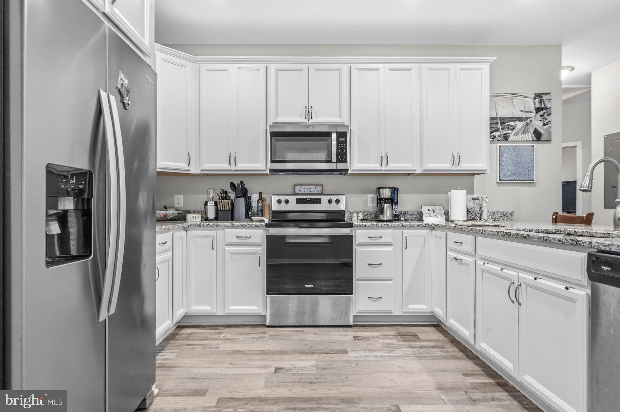 324 3rd Street Colonial Beach, VA 22443 - Photo 12 of 37 a kitchen with a refrigerator stove and white cabinets
