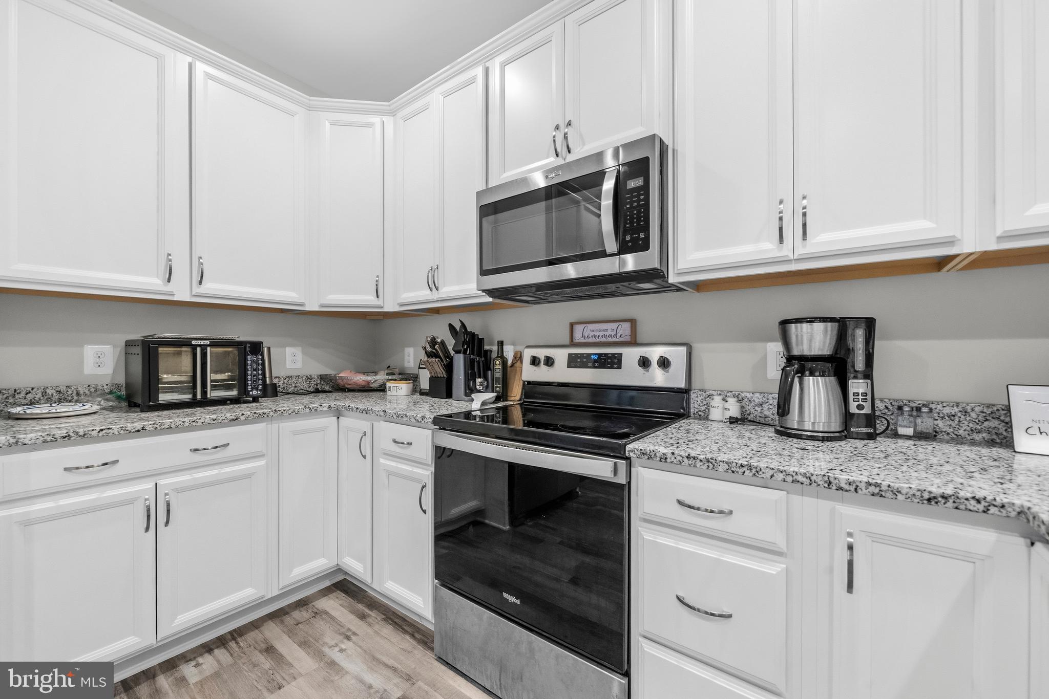 324 3rd Street Colonial Beach, VA 22443 - Photo 14 of 37 a kitchen with granite countertop white cabinets stainless steel appliances and a sink