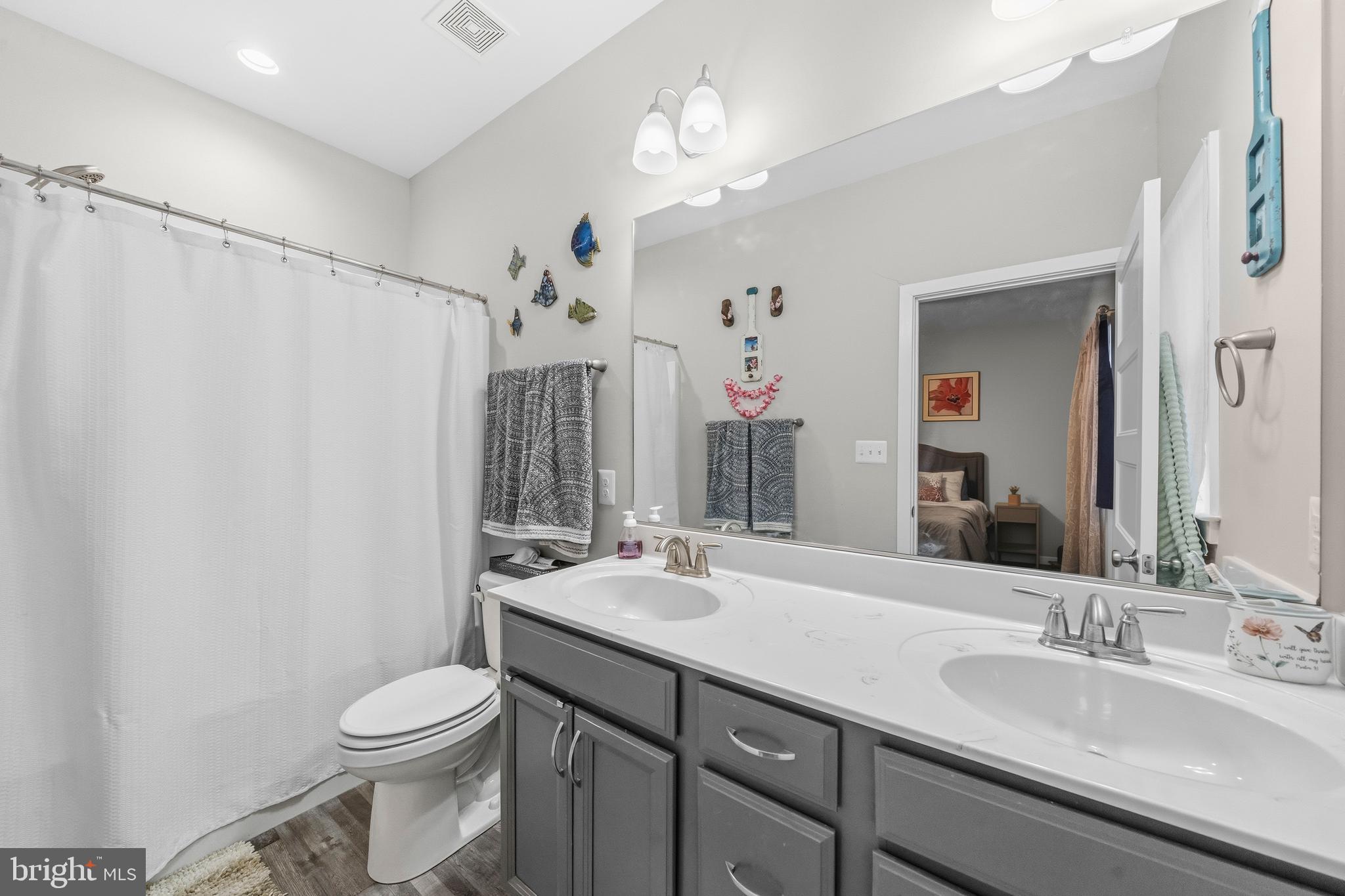 324 3rd Street Colonial Beach, VA 22443 - Photo 20 of 37 a bathroom with a double vanity sink toilet and a mirror