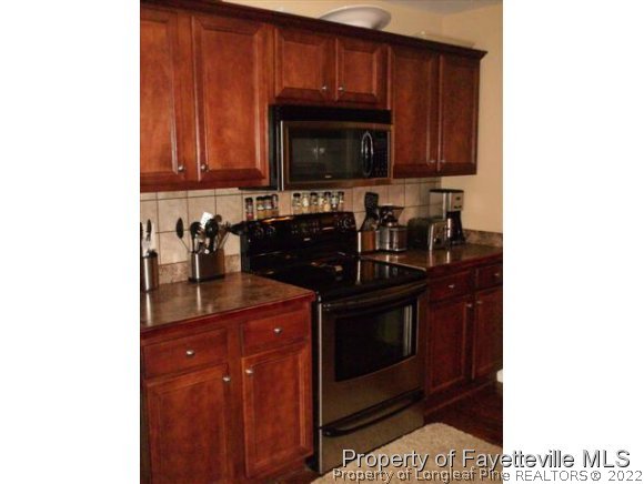 211 Booth Pond Road Raeford, NC 28376 - Photo 12 of 25 a kitchen with stainless steel appliances granite countertop a stove a sink and a microwave
