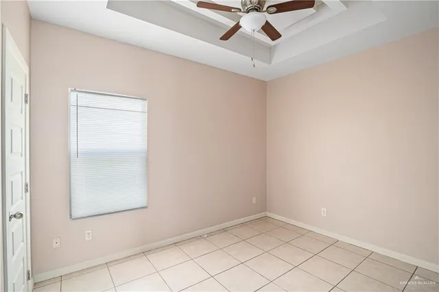 an empty room with a window and a ceiling fan