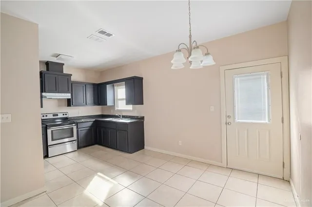a large kitchen with stainless steel appliances granite countertop a stove sink and cabinets