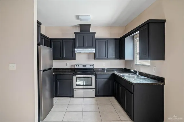 a kitchen with stainless steel appliances granite countertop a stove a sink and a microwave