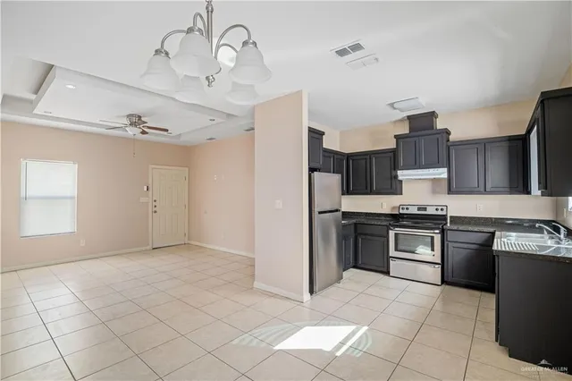 a large kitchen with cabinets and stainless steel appliances
