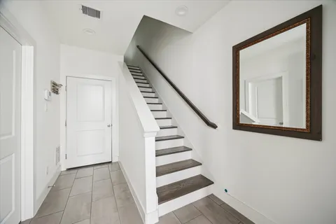 a view of a hallway with front door wooden floor and stairs