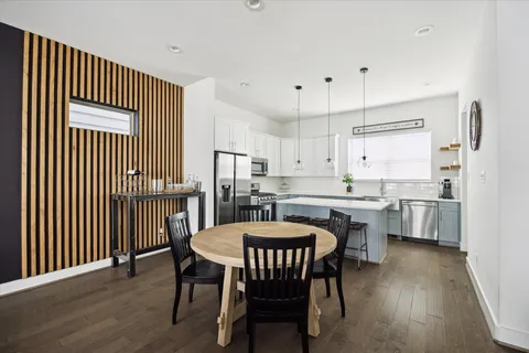 a kitchen with a dining table chairs and white cabinets