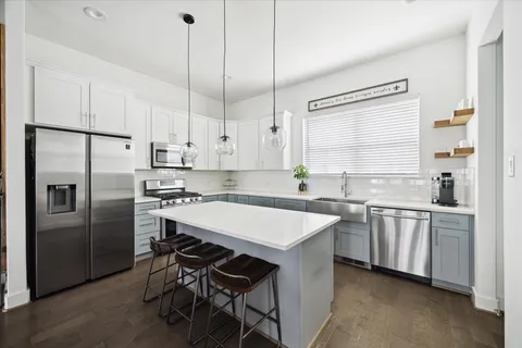 a kitchen with stainless steel appliances granite countertop a white cabinets and a refrigerator